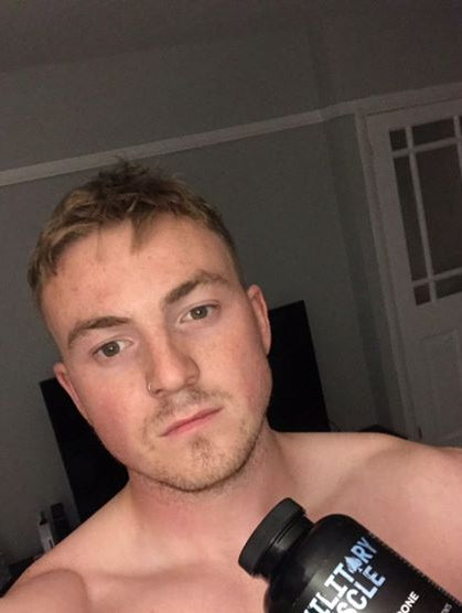 a shirtless man holding a package of military muscle 