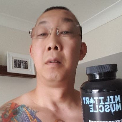 a shirtless man holding a package of military muscle 